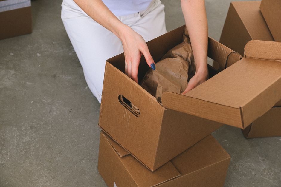 Movers carefully packing household items into sturdy cardboard boxes